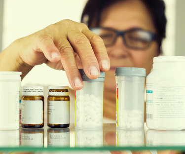 Woman reading prescriptions bottles